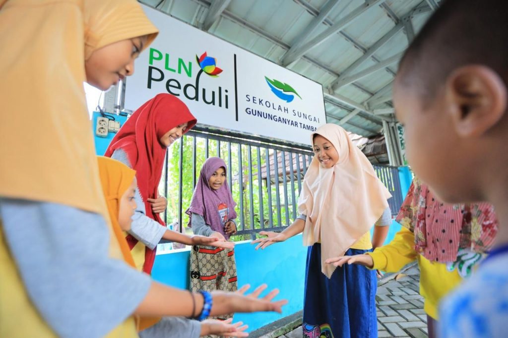 Anak-anak Sekolah Informal Sungai Gunung Anyar bermain bersama di Surabaya