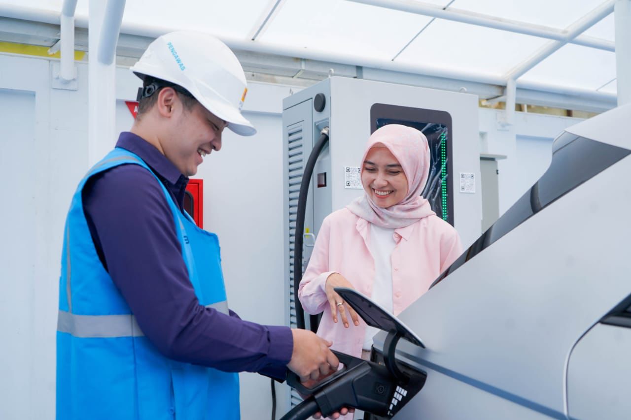 Petugas PLN membantu pengguna EV mengisi daya di SPKLU