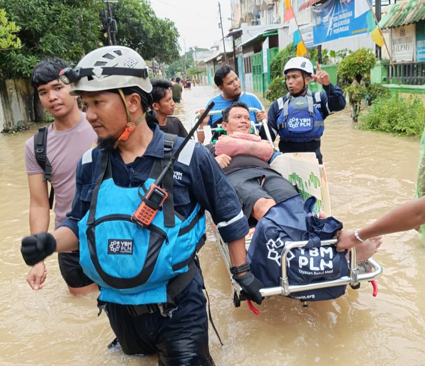 Potret aksi cepat Tim Yayasan Baitul Maal (YBM) PLN membantu evakuasi warga yang terdampak banjir di Medan.