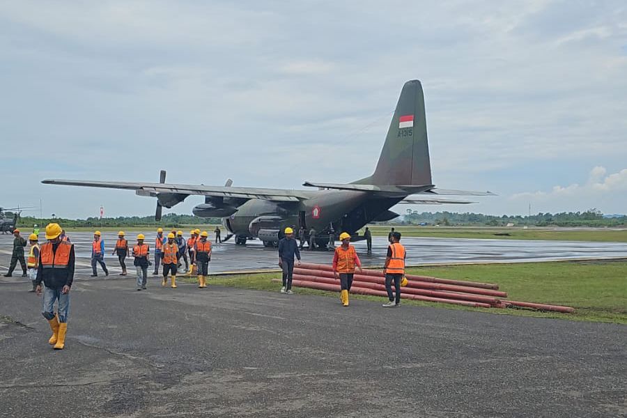 Petugas PLN dan personel TNI memasukkan material perbaikan jaringan listrik ke pesawat Hercules untuk dikirim ke wilayah terdampak bencana.